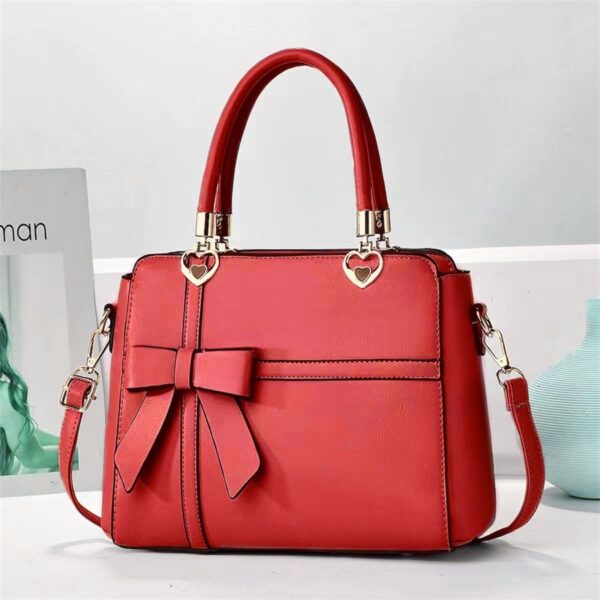 Elegant Bow-adorned Satchel Handbag With Heart Charm Handles And Removable Shoulder Strap
