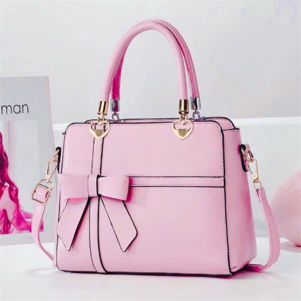 Elegant Bow-adorned Satchel Handbag With Heart Charm Handles And Removable Shoulder Strap