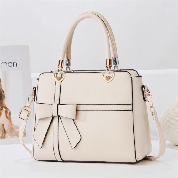 Elegant Bow-adorned Satchel Handbag With Heart Charm Handles And Removable Shoulder Strap