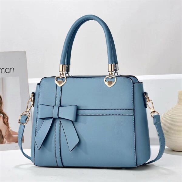 Elegant Bow-adorned Satchel Handbag With Heart Charm Handles And Removable Shoulder Strap