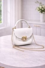 Polished Jelly Saddle Bag With Sculpted Metallic Clasp And Gold Tone Chain